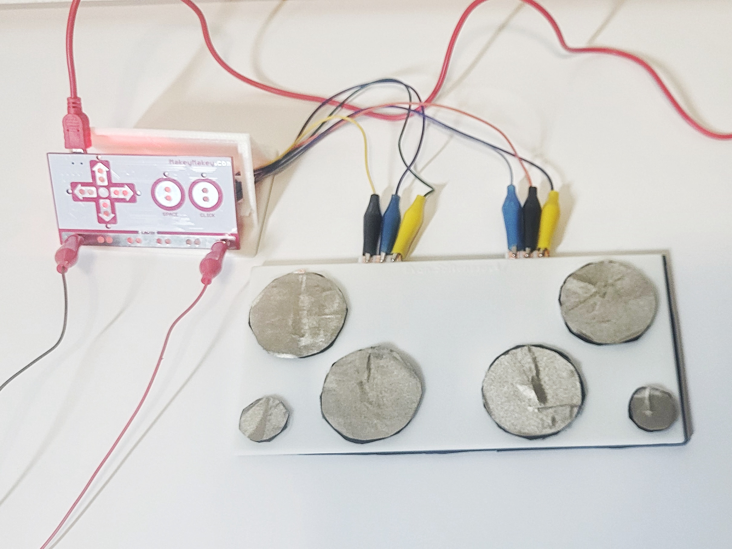 Close-up image of the full 3D printed drumkit, drumsticks, stand, and MakeyMakey